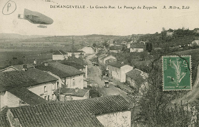Demangevelle. La grande rue. Le passage du zeppelin. Carte postale. © Jérôme  Mongreville (reproduction) / Région Bourgogne-Franche-Comté, Inventaire du patrimoine - 2015 Demangevelle. La grande rue. Le passage du zeppelin. Carte postale. © Jérôme  Mongreville (reproduction) / Région Bourgogne-Franche-Comté, Inventaire du patrimoine - 2015