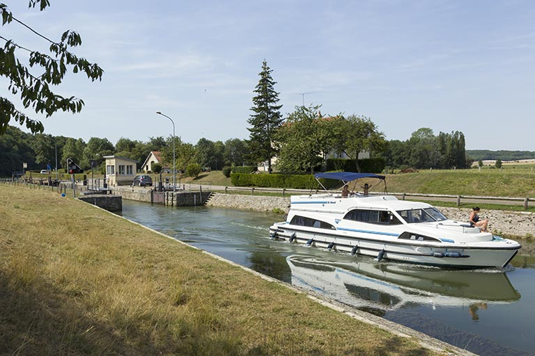 Bateau remontant le canal après avoir franchi l'écluse. © Sonia Dourlot / Région Bourgogne-Franche-Comté, Inventaire du patrimoine - 2015 Bateau remontant le canal après avoir franchi l'écluse. © Sonia Dourlot / Région Bourgogne-Franche-Comté, Inventaire du patrimoine - 2015