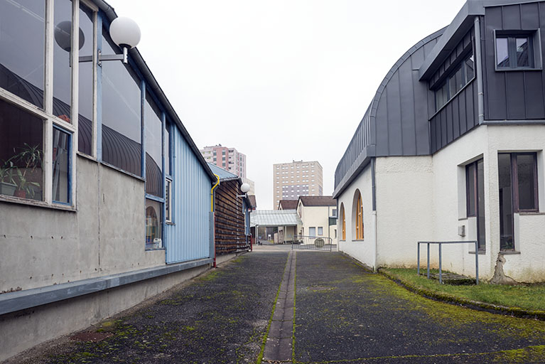 Depuis l'ouest, vue entre le bâtiment d'administration et les ateliers, face à la place. © Mary Ruffinoni / Région Bourgogne-Franche-Comté, Inventaire du patrimoine - 2015