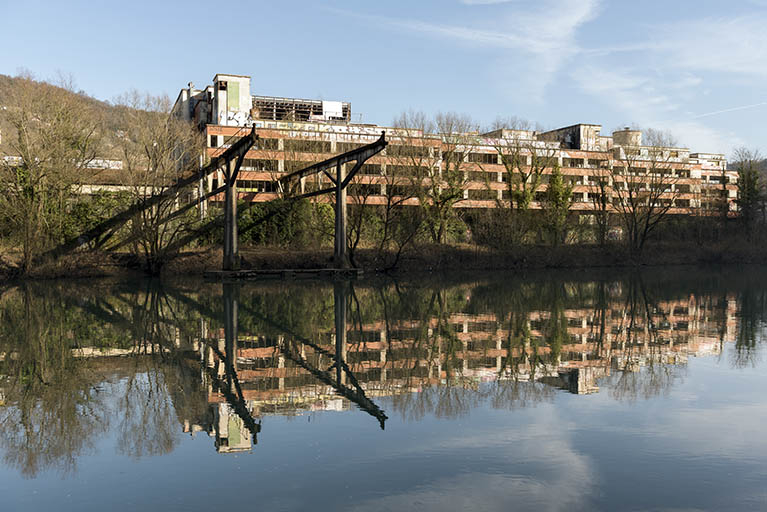 Etat en 2016. Usine A : façade sud des ateliers d'étirage et filature tergal et nylon, et portique du pont roulant, depuis la rive gauche du Doubs. © Sonia Dourlot / Région Bourgogne-Franche-Comté, Inventaire du patrimoine - 2016