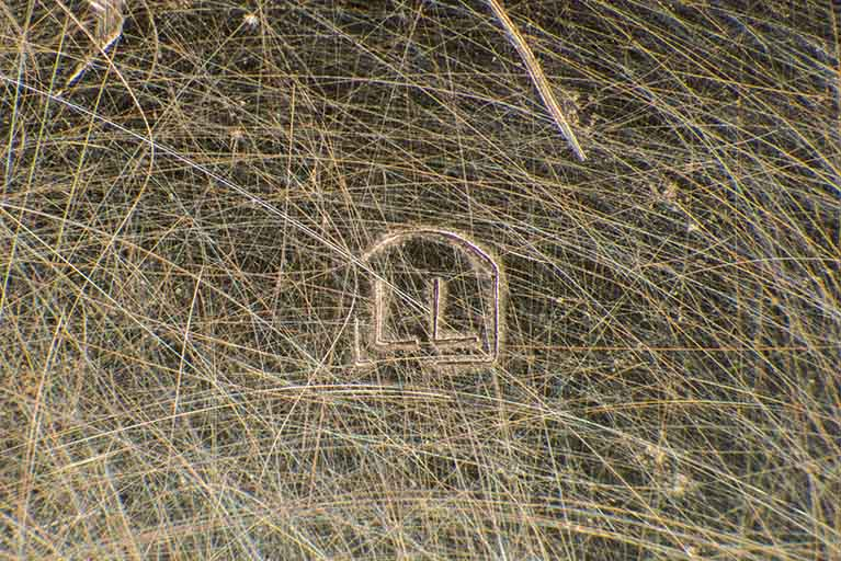 Poinçon d'origine étrangère (lettres LL), gravé dans le fond. © Sonia Dourlot / Région Bourgogne-Franche-Comté, Inventaire du patrimoine - 2016