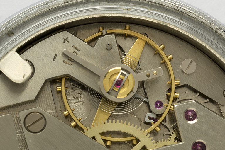 4e montre, mouvement Parrenin HP 40 : numéro de modèle Lip (R 167) gravé près du pont de balancier. Mal effacée, la pointe supérieure du logotype Parrenin est visible à gauche, près d'une vis du balancier. © Sonia Dourlot / Région Bourgogne-Franche-Comté, Inventaire du patrimoine - 2016