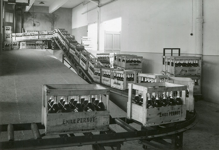 Caisses de bouteilles sur convoyeur à rouleaux, photogr., s.d. [milieu 20e siècle]. © Stainacre / Région Bourgogne-Franche-Comté, Inventaire du patrimoine - 2016