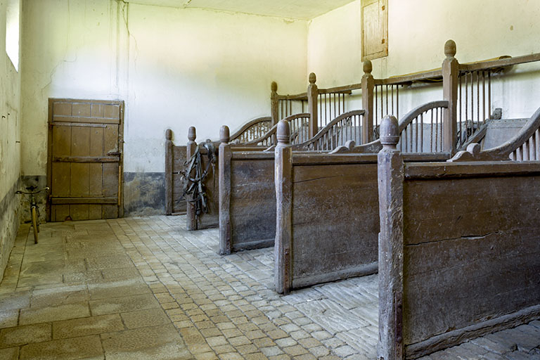 Intérieur de l'écurie : vue générale des stalles. © Sonia Dourlot / Région Bourgogne-Franche-Comté, Inventaire du patrimoine - 2016