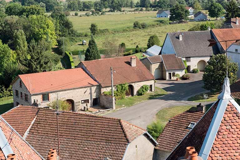 Vue des fermes alignées le long de la rue Grande, depuis le toit-terrasse du donjon du château. © Sonia Dourlot / Région Bourgogne-Franche-Comté, Inventaire du patrimoine - 2016 Vue des fermes alignées le long de la rue Grande, depuis le toit-terrasse du donjon du château. © Sonia Dourlot / Région Bourgogne-Franche-Comté, Inventaire du patrimoine - 2016