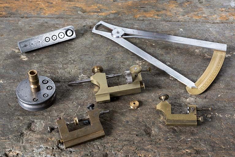 Exemple d'outils fabriqués dans l'atelier : outils à redresser les roues de cylindre (à gauche), au dixième (en haut à droite), à centrer et rapporter les pivots (les trois en bas autour d'un cuivrot, celui du haut étant dit à 12 cornets). © Sonia Dourlot / Région Bourgogne-Franche-Comté, Inventaire du patrimoine - 2017