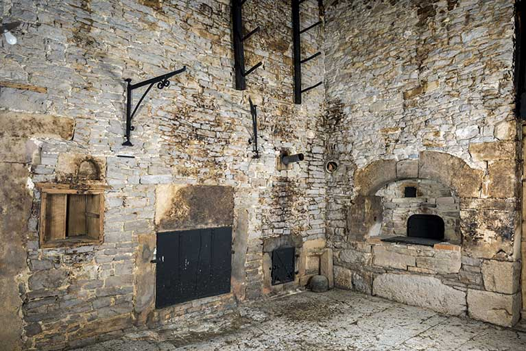 Intérieur, "tué" central : plaque de cheminée (commune au "poêle" voisin) et trappe du poêle en faïence à gauche, four à pain à droite. © Sonia Dourlot / Région Bourgogne-Franche-Comté, Inventaire du patrimoine - 2017 Intérieur, "tué" central : plaque de cheminée (commune au "poêle" voisin) et trappe du poêle en faïence à gauche, four à pain à droite. © Sonia Dourlot / Région Bourgogne-Franche-Comté, Inventaire du patrimoine - 2017