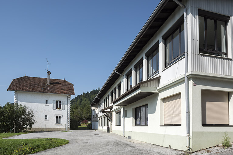 Façade latérale droite de la maison et façade antérieure de l'usine, vue en enfilade. © Sonia Dourlot / Région Bourgogne-Franche-Comté, Inventaire du patrimoine - 2017
