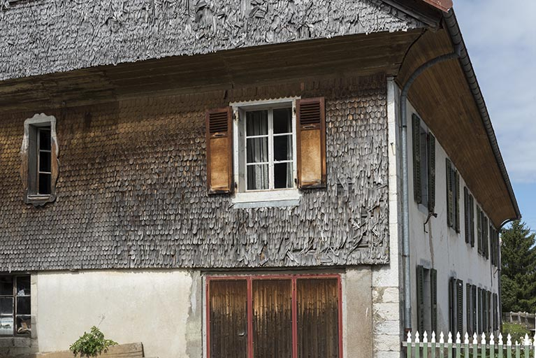 Façade latérale gauche : essentage de tavaillons, avec la façade antérieure en enfilade. © Sonia Dourlot / Région Bourgogne-Franche-Comté, Inventaire du patrimoine - 2017 Façade latérale gauche : essentage de tavaillons, avec la façade antérieure en enfilade. © Sonia Dourlot / Région Bourgogne-Franche-Comté, Inventaire du patrimoine - 2017