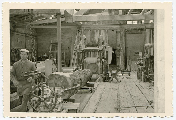 [Sciage au gros châssis de scie Socolest, vu depuis le fond de l'atelier : un tronc d'arbre est approché de la scie], années 1960. © auteur / Région Bourgogne-Franche-Comté, Inventaire du patrimoine - 2017