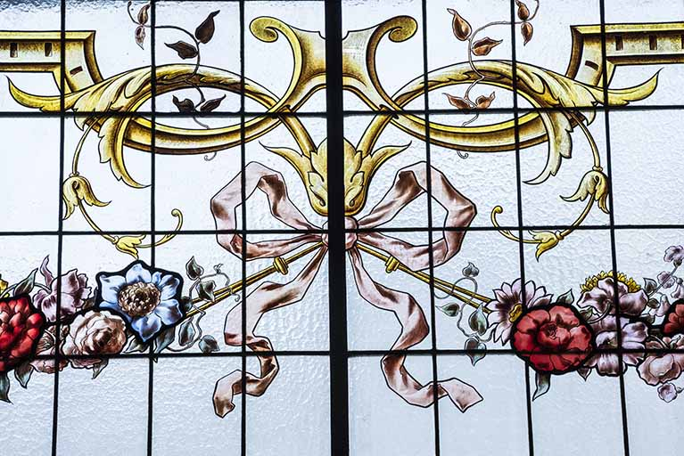 Verrière côté rue, déatil : le neoud plat reliant les eux guirlandes à fleurs. © Jérôme Mongreville / Région Bourgogne-Franche-Comté, Inventaire du patrimoine - 2017