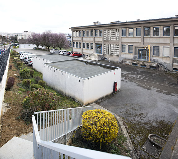Façade antérieure : corps oriental, de trois quarts droite. Garages préfabriqués au premier plan. © Sonia Dourlot / Région Bourgogne-Franche-Comté, Inventaire du patrimoine - 2019