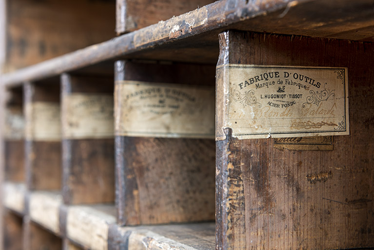 Bâtiment au 2 rue du Chêne, étage de soubassement (magasin industriel) : étiquettes sur les parois du meuble servant au stockage des outils. © Sonia Dourlot / Région Bourgogne-Franche-Comté, Inventaire du patrimoine - 2019 Bâtiment au 2 rue du Chêne, étage de soubassement (magasin industriel) : étiquettes sur les parois du meuble servant au stockage des outils. © Sonia Dourlot / Région Bourgogne-Franche-Comté, Inventaire du patrimoine - 2019