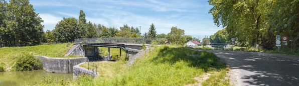 Vue d'ensemble de la porte de garde et du pont la surmontant. En arrière-plan, on distingue le centre d'exploitation de VNF et le pont ferroviaire. © Région Bourgogne-Franche-Comté, Inventaire du patrimoine