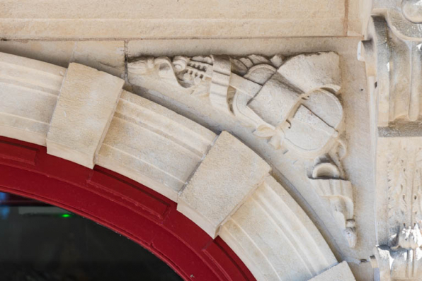 Façade antérieure : instruments de musique sculptés sur l'écoinçon droit de l'entrée. © Région Bourgogne-Franche-Comté, Inventaire du patrimoine