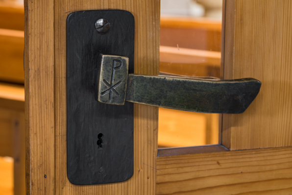 Détail de la poignée de la porte séparant la salle de culte du hall d'accueil. © Région Bourgogne-Franche-Comté, Inventaire du patrimoine Détail de la poignée de la porte séparant la salle de culte du hall d'accueil. © Région Bourgogne-Franche-Comté, Inventaire du patrimoine