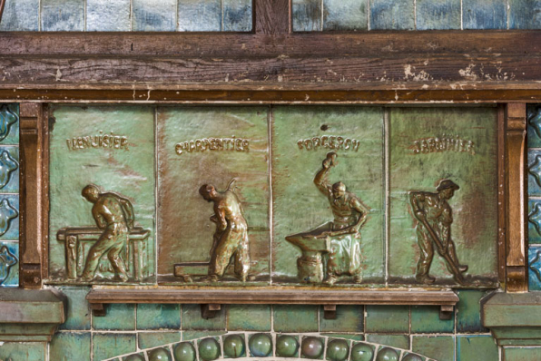 Partie inférieure de la hotte, détail : menuisier, charpentier, forgeron et jardinier. © Région Bourgogne-Franche-Comté, Inventaire du patrimoine Partie inférieure de la hotte, détail : menuisier, charpentier, forgeron et jardinier. © Région Bourgogne-Franche-Comté, Inventaire du patrimoine