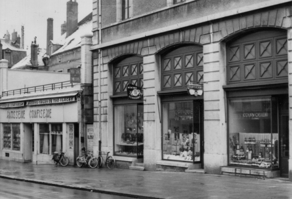 [Devanture des magasins occupant les trois travées gauche de l'élévation avenue de la Gare]. S.d. [1965 ou 1966]. © Région Bourgogne-Franche-Comté, Inventaire du patrimoine