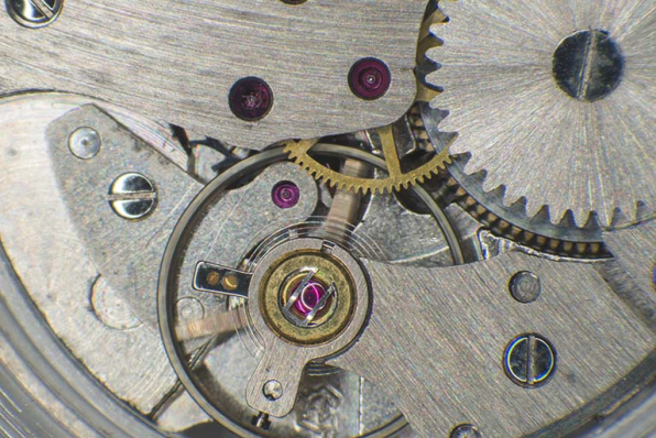Mouvement de montre France Ebauches FE 140 : détail du balancier-spiral (surmontant l'échappement à ancre) muni de son système antichoc à rubis synthétique. © Région Bourgogne-Franche-Comté, Inventaire du patrimoine Mouvement de montre France Ebauches FE 140 : détail du balancier-spiral (surmontant l'échappement à ancre) muni de son système antichoc à rubis synthétique. © Région Bourgogne-Franche-Comté, Inventaire du patrimoine
