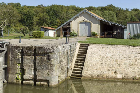 Vue partielle d'un bajoyer de l'écluse, perré et remise en arrière plan. © Région Bourgogne-Franche-Comté, Inventaire du patrimoine