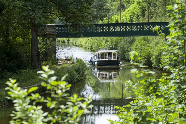 Vue sur la passerelle enjambant le canal sur lequel navigue un bateau de plaisance. © Région Bourgogne-Franche-Comté, Inventaire du patrimoine