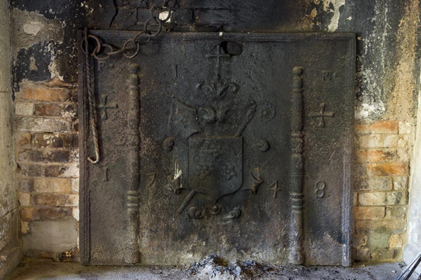 Intérieur du logis : la plaque de cheminée en réemploi, portant la date 1748 et des armoires non identifiées. © Région Bourgogne-Franche-Comté, Inventaire du patrimoine