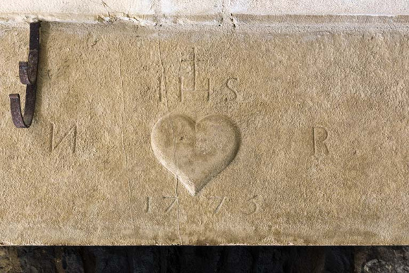 Cheminée : détail du faux manteau. Date portée : 1775. Deux initiales : N R de part et d'autre d'un coeur surmonté d'IHS.   © Région Bourgogne-Franche-Comté, Inventaire du patrimoine