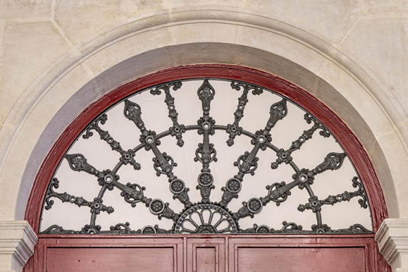 Vestibule, porte côté cour : grille en fonte du tympan. © Région Bourgogne-Franche-Comté, Inventaire du patrimoine