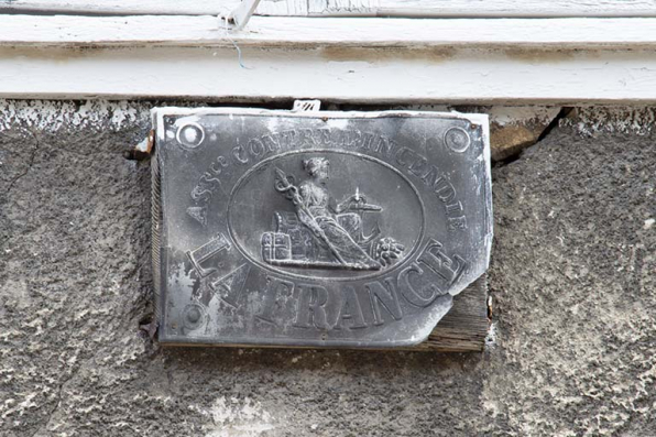 Façade sur la rue Charles Magnin (étage supérieur). Plaque d'assurance La France. © Région Bourgogne-Franche-Comté, Inventaire du patrimoine Façade sur la rue Charles Magnin (étage supérieur). Plaque d'assurance La France. © Région Bourgogne-Franche-Comté, Inventaire du patrimoine