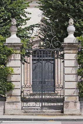 Porte principale à travers la grille du portail de la cour. © Région Bourgogne-Franche-Comté, Inventaire du patrimoine