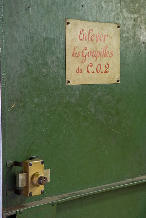 Détail de la porte métallique de la salle à relais : plaque de signalétique du système d'extinction des incendies au CO2. © Région Bourgogne-Franche-Comté, Inventaire du patrimoine