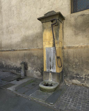 Vue de la fontaine à bras situé sur le mur de l'église, place du Prieuré. © Région Bourgogne-Franche-Comté, Inventaire du patrimoine