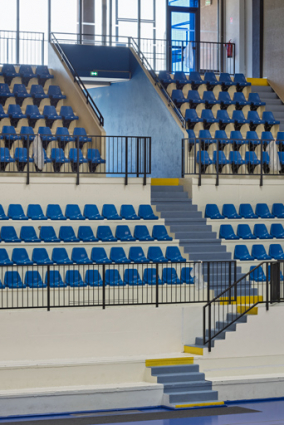 Maison des sports, grand gymnase : circulations dans les gradins côté Loire. L'escalier donne accès à une galerie vitrée. © Région Bourgogne-Franche-Comté, Inventaire du patrimoine Maison des sports, grand gymnase : circulations dans les gradins côté Loire. L'escalier donne accès à une galerie vitrée. © Région Bourgogne-Franche-Comté, Inventaire du patrimoine