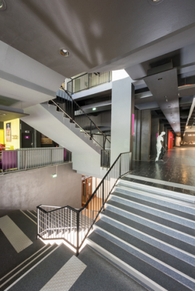 Maison de la culture : escalier dans le hall desservant l'étage de soubassement et le 1er étage. © Région Bourgogne-Franche-Comté, Inventaire du patrimoine Maison de la culture : escalier dans le hall desservant l'étage de soubassement et le 1er étage. © Région Bourgogne-Franche-Comté, Inventaire du patrimoine