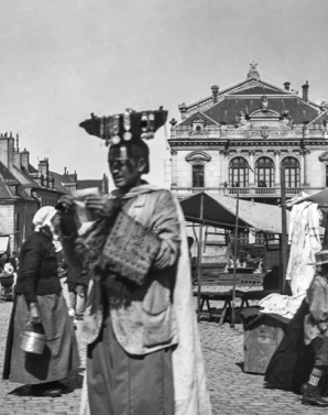 [Marché et colporteur en avant du théâtre : détail]. S.d. [limite 19e siècle 20e siècle]. © Région Bourgogne-Franche-Comté, Inventaire du patrimoine