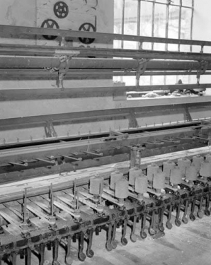 Détail du module de gauche, vu de trois quarts.De bas en haut, système de freinage des broches au pied, broches et leur courrois d'entrainement, système de guidage des fils et moulins. © Région Bourgogne-Franche-Comté, Inventaire du patrimoine