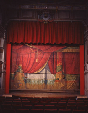 Intérieur : détail du rideau de scène, avec sièges des premiers rangs. © Région Bourgogne-Franche-Comté, Inventaire du patrimoine