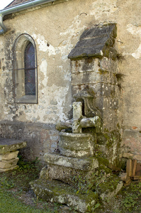 Fragments de sculpture et de crucifix le long du mur extérieur nord. © Région Bourgogne-Franche-Comté, Inventaire du patrimoine