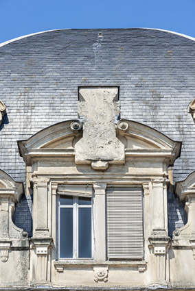 Bâtiment d'entrée, façade antérieure : lucarne attique et bloc en attente de sculpture. © Région Bourgogne-Franche-Comté, Inventaire du patrimoine