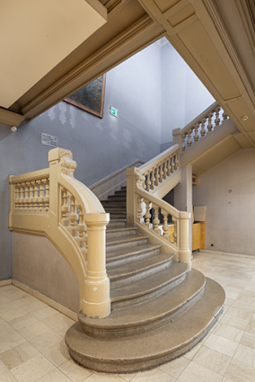 Bâtiment d'entrée, vestibule : escalier desservant le 1er étage, de trois quarts gauche. © Région Bourgogne-Franche-Comté, Inventaire du patrimoine