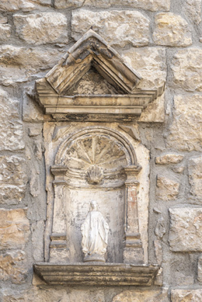 Remploi d'éléments sculptés dans le mur est du bâtiment sur rue, provenant de l'église. © Région Bourgogne-Franche-Comté, Inventaire du patrimoine
