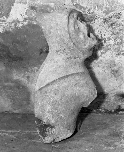 Gargouille en forme de personnage déposée dans la nef, profil droit. © Jean-Luc Duthu / Région Bourgogne-Franche-Comté, Inventaire du patrimoine - 1987