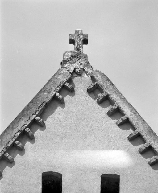 Tête surmontée d'une croix au sommet du pignon du choeur. © Michel Rosso / Région Bourgogne-Franche-Comté, Inventaire du patrimoine - 2003