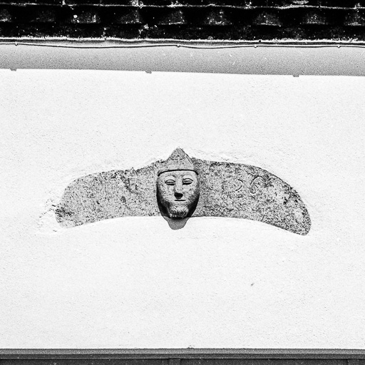 Maison cadastrée 1964 AC 107 : tête sculptée en façade. © Bernard Pontefract / Région Bourgogne-Franche-Comté, Inventaire du patrimoine - 1975