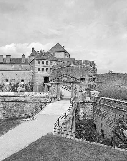 Vue éloignée. Porte Louis XIV - tour bastionnée de la 4e enceinte. En arrière-plan : tour en "fer à cheval" et 3e enceinte. © Yves Sancey / Région Bourgogne-Franche-Comté, Inventaire du patrimoine - 1980