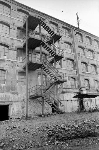 Extension des années 1892 : escalier métallique sur la façade postérieure (état en 1981). SRI. Enquête régionale sur les bâtiments industriels (1979-1981). © Jack Dumont / Région Bourgogne-Franche-Comté, Inventaire du patrimoine - 1981