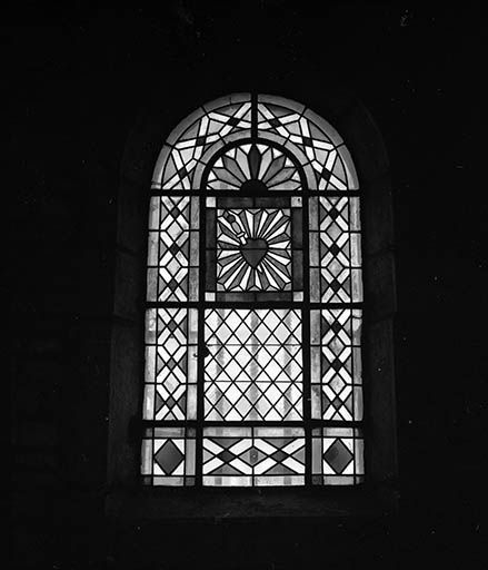 Baie n° 4 réalisée au 19e siècle : vitrerie géométrique colorée avec le coeur du Christ au registre supérieur, un complément en verre du 20e siècle. © Jean-Luc Ligier / Région Bourgogne-Franche-Comté, Inventaire du patrimoine - 1982