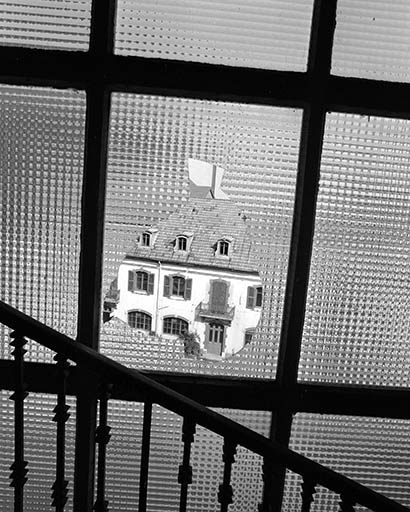 Façade sur cour des bureaux (extrémité occidentale), vue au travers d'une vitre brisée. © Yves Sancey / Région Bourgogne-Franche-Comté, Inventaire du patrimoine - 1992