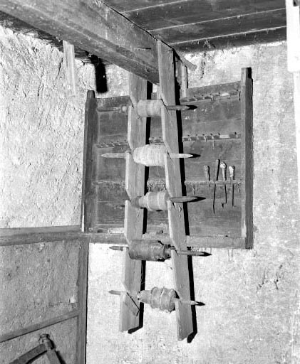 Rateliers. Le ratelier du second plan accueille les outils du tourneur, celui du premier plan (portant des axes) semble ne pas avoir de lien avec le tour. © Jérôme Mongreville / Région Bourgogne-Franche-Comté, Inventaire du patrimoine - 1994