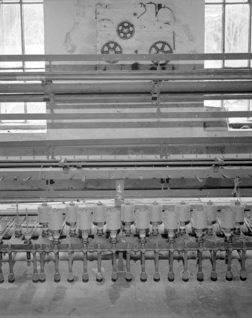 Détail du module de gauche, montrant 15 broches.De bas en haut, système de freinage des broches au pied, broches, système de guidage des fils et moulins. © Yves Sancey / Région Bourgogne-Franche-Comté, Inventaire du patrimoine - 1994